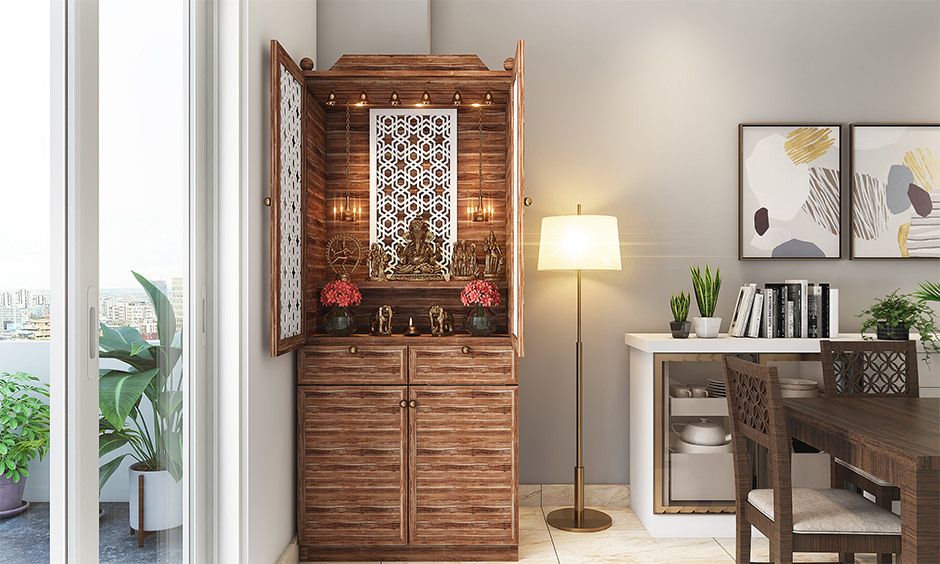 Stylish pooja unit design in living room made of natural wood, featuring subtle carvings and warm tones.