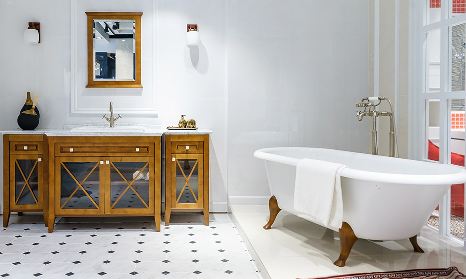 Wooden freestanding vanity with glass doors complements white walls and floor.