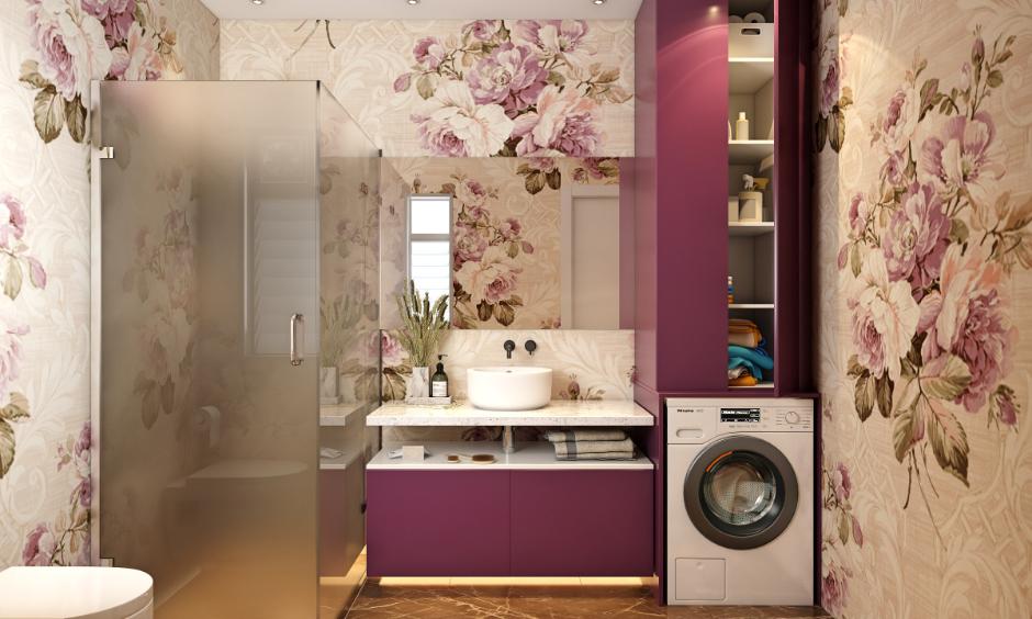 Modern bathroom with pink floral wallpaper, purple cabinets, and a built-in washing machine.