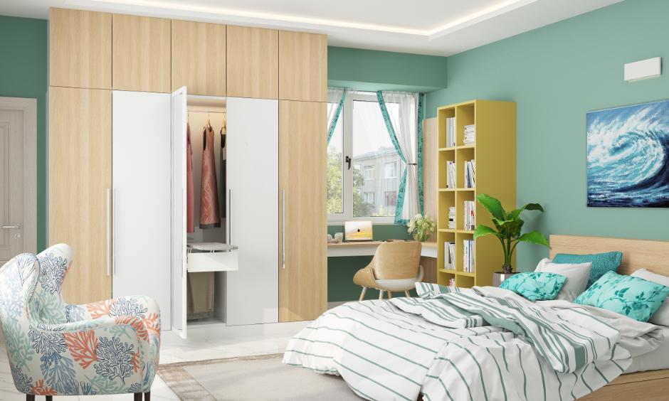 Green bedroom design with mint green walls, teal bedding, and a tall plant.